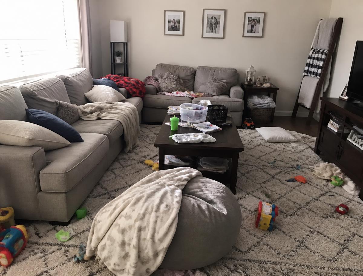Living room with scattered clutter before cleaning